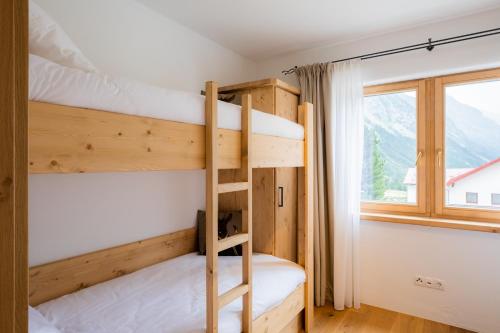 a couple of bunk beds in a room with a window at das Chaletdorf - Pitztal in Sankt Leonhard im Pitztal