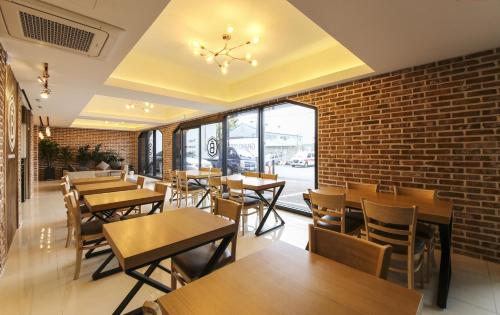 a restaurant with tables and chairs and a brick wall at Busan Station BUSAN VIEW HOTEL in Busan