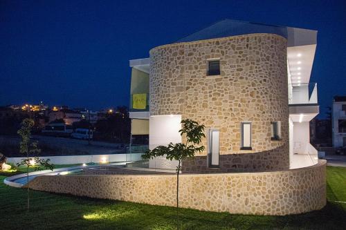 a building with a stone tower at night at La Pierre in Limenaria