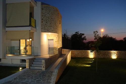 a building with a balcony at night with lights at La Pierre in Limenaria