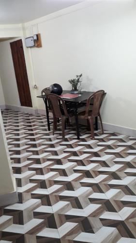 a dining room with a table and chairs on a geometric floor at White Tara home stay in Darjeeling