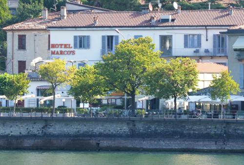 un edificio con alberi di fronte a un fiume di Hotel Marco's a Como
