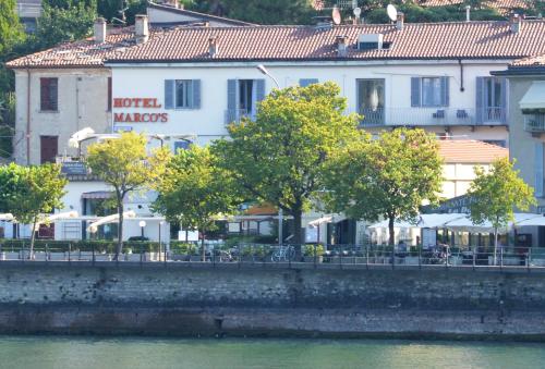 a building with trees in front of a river at Hotel Marco's in Como