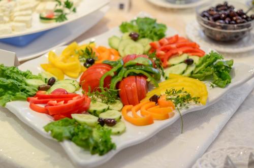 a white plate of vegetables on a table at Hotel Naxos Beach in Naxos Chora
