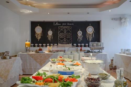 a table with many plates of food on it at Hotel Naxos Beach in Naxos Chora
