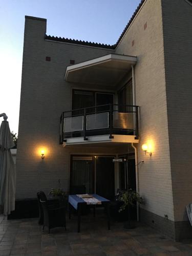 a building with a balcony and a table on a patio at La Nuova Casa del Campo (vh De Kamp) in Dinxperlo