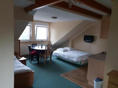 um quarto com uma cama e uma mesa e uma cama e um quarto com em Hotel Du Donon em Grandfontaine