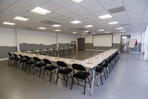 a large conference room with a long table and chairs at Kyriad Clermont-Ferrand-Sud - La Pardieu in Clermont-Ferrand