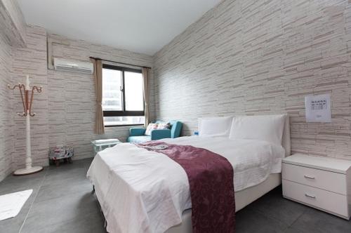 a bedroom with a large white bed and a chair at Yixiang Spring Travel in Jiaoxi