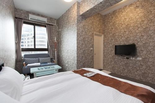 a bedroom with a bed and a tv on a wall at Yixiang Spring Travel in Jiaoxi