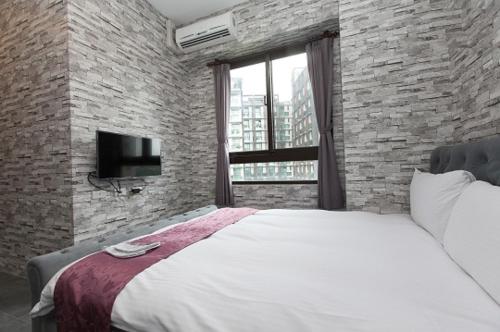 a bedroom with a large bed and a tv at Yixiang Spring Travel in Jiaoxi