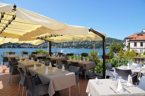 a restaurant with tables and chairs and umbrellas at Hotel Marco's in Como