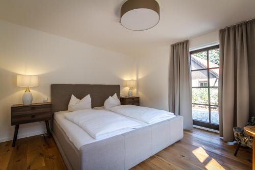 a large white bed in a bedroom with a window at Pension Kleiner König in Struppen-Siedlung
