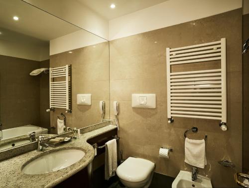 a bathroom with a sink and a toilet and a phone at Meditur Hotel Bologna in Bologna