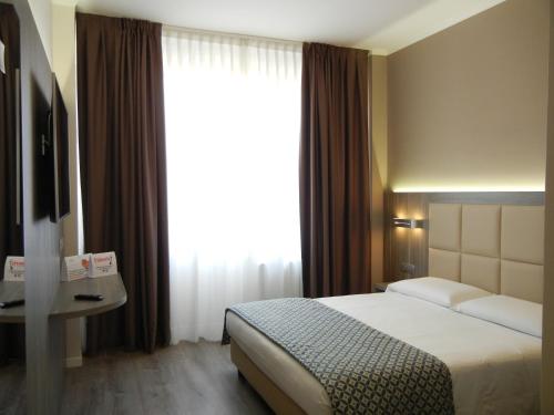 a hotel room with a bed and a large window at Delle Nazioni Milan Hotel in Milan