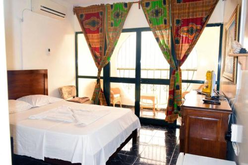 a bedroom with a bed and a large window at Hotel Miramar Fogo Brava in São Filipe