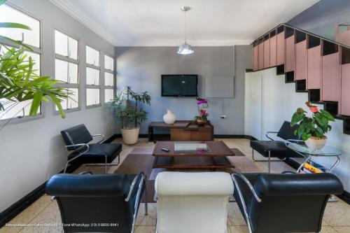 a living room with a table and chairs at Hotel Princeton in Piracicaba