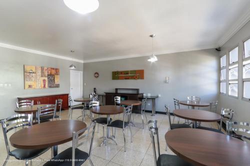 a dining room with wooden tables and chairs at Hotel Princeton in Piracicaba