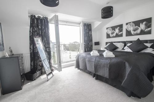 a bedroom with a bed and a large window at Woodlands Luxury 4 Bedroom Townhouse Cults in Aberdeen