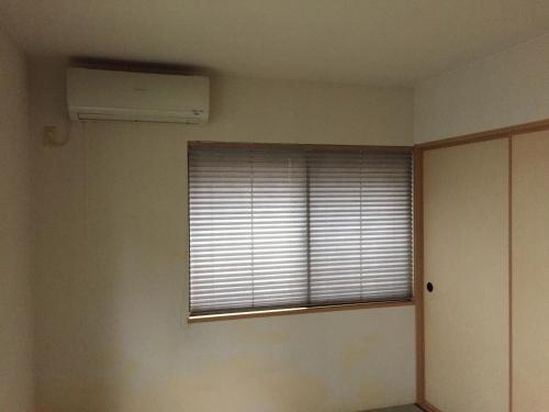 a room with a window with a air conditioner at South Wind Chalet in Itoshima