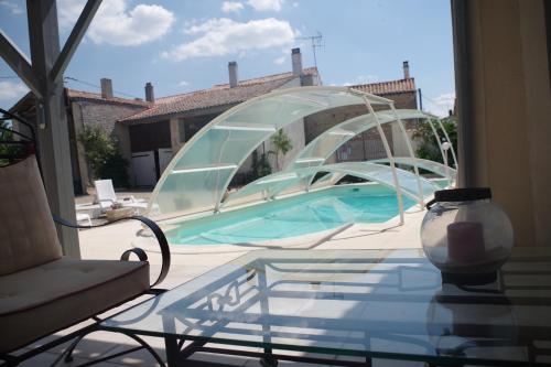 a glass table with a glass bridge in a yard at Les Lavandières in Saint-Hilaire-la-Palud