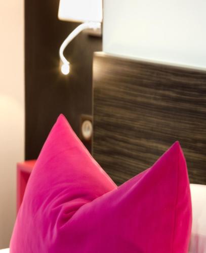 a pink pillow sitting on top of a bed at Best Western Plus Monopole Métropole in Strasbourg