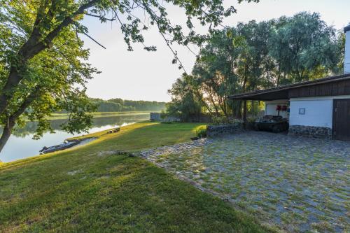 a house with a car parked next to a lake at Гостинний двір на хуторі Хрещатик in Khreshchatik