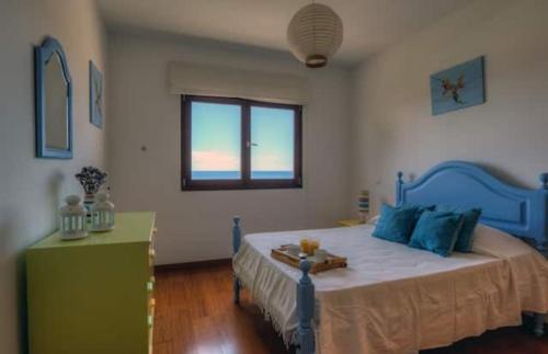 ポルト・サントにある3-Bedroom Summer Villaのベッドルーム(青いベッド1台、窓付)