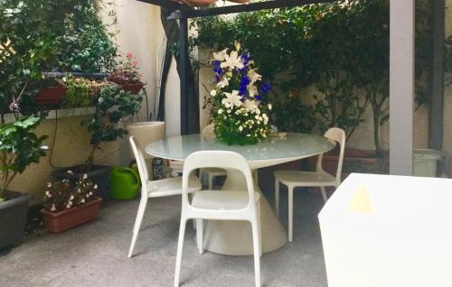 a table with chairs and a vase of flowers on it at Villa Maria in Turin