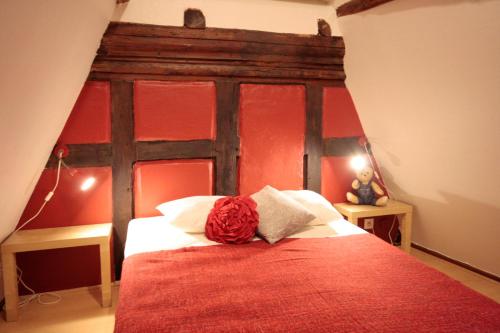 Schlafzimmer mit einem Bett mit rotem Kopfteil in der Unterkunft Appartement Zum Bären avec Parking in Colmar