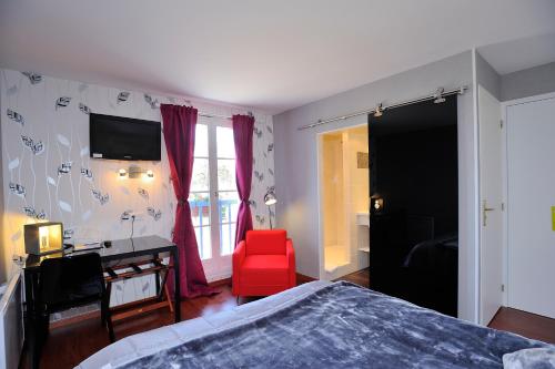 a bedroom with a bed and a red chair at Logis Aux Maisons in Maisons-lès-Chaource