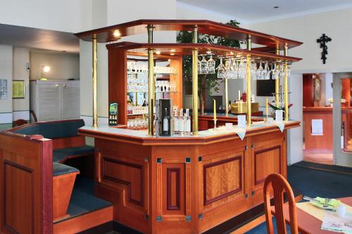 a bar in a restaurant with a counter and chairs at Hotel Schwarzes Ross in Siebenlehn