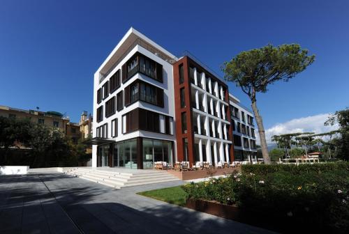 a large red and white building with a tree at Principe Forte Dei Marmi - Resort & Spa in Forte dei Marmi
