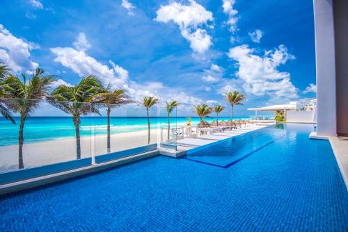 a pool with a view of the beach at Wyndham Alltra Cancun All Inclusive Resort in Cancún