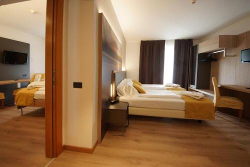 a bedroom with a bed and a desk with a chair at Ambassador Suite Hotel in Riva del Garda