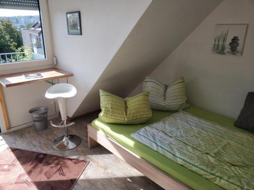 a bedroom with a green bed and a window at Lovely Studio in Cannstatt in Stuttgart