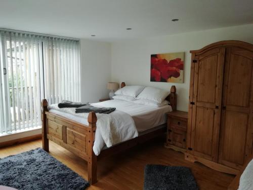 a bedroom with a bed and a large window at Brown Cow Cottage in Dalton in Furness