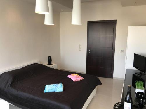 a bedroom with a black bed with two bags on it at Heart City Executive Suite in Chania
