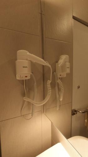 a bathroom with a phone hanging on a wall at U Design Hotel Kuala Lipis in Kuala Lipis