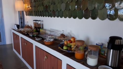 a kitchen counter with a bowl of fruit and juice at Casa da Ermida de Santa Catarina in Santa Eulália