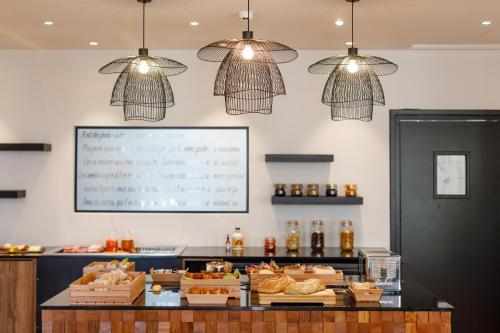 a bakery with pastries on a counter with lights at Hotel Verlaine in Cannes
