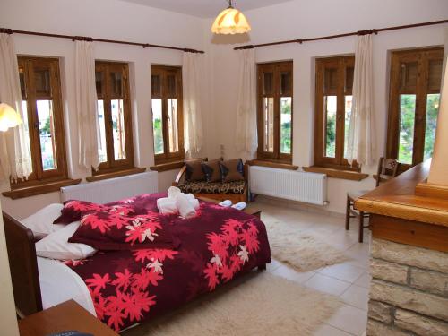 een slaapkamer met een bed met een rood dekbed bij Hotel Ilianna in Portariá