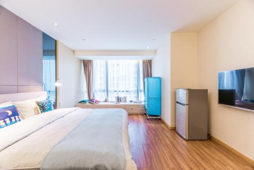 a bedroom with a large bed and a flat screen tv at Chengdu Hi - Tech·Global Center Locals Apartment 00139620 in Chengdu