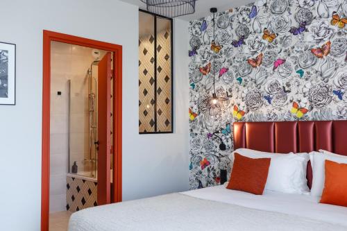 a bedroom with a bed and a floral wall at Hotel Verlaine in Cannes