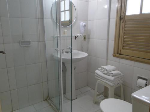 a bathroom with a shower and a sink and a toilet at Atlântico Hotel in Santos