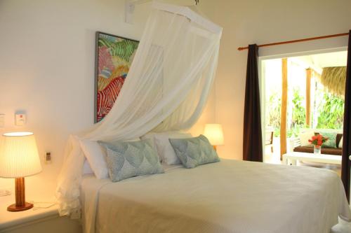 a bedroom with a white bed with a canopy at Caribbean Beach Villa Playa Bonita Las Terrenas in Las Terrenas
