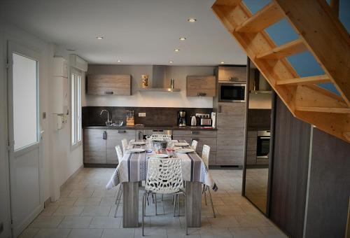 een keuken met een tafel en stoelen in een kamer bij Le Nid Des Grands Geais in Le Crotoy