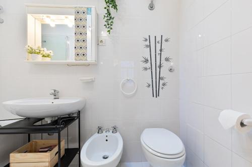 a white bathroom with a toilet and a sink at Rome As You Feel - Monti Apartment in Rome