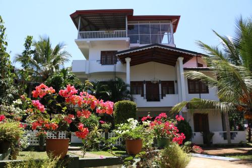 a house with flowers in front of it at Kandy City Village in Kandy