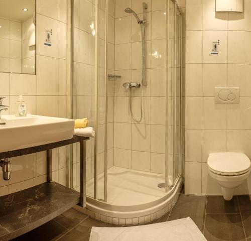 a bathroom with a shower and a sink and a toilet at Gästehaus Hausberger in Schruns